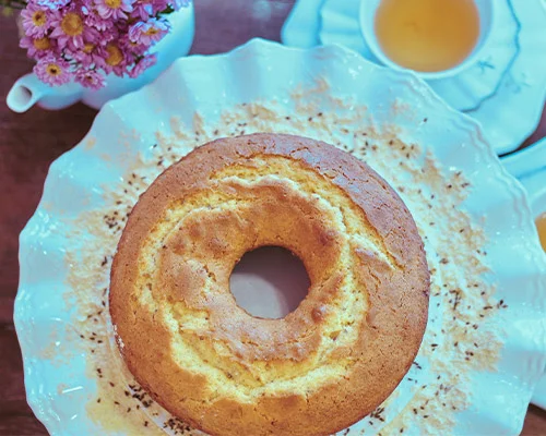 Bolo de laranja feito na air fryer e servido ao lado de uma xicara